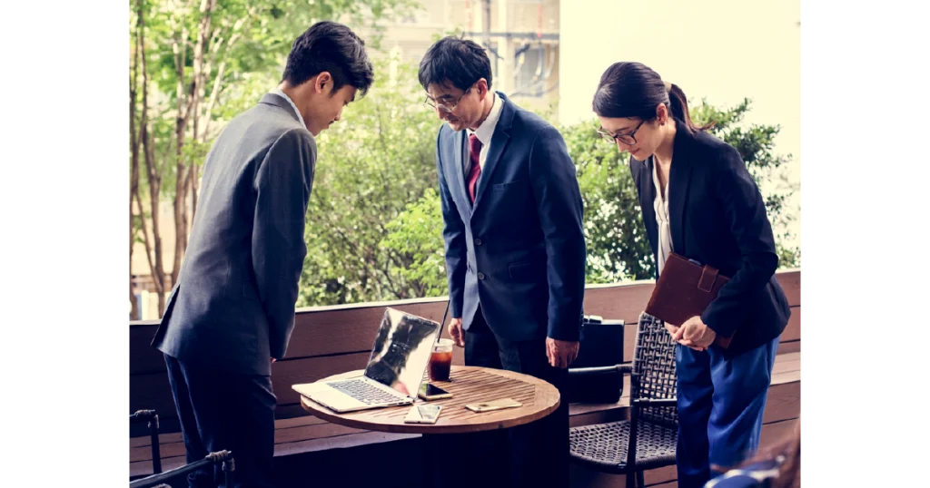 Japanese and Chinese business professionals in a meeting, showcasing cultural communication differences.