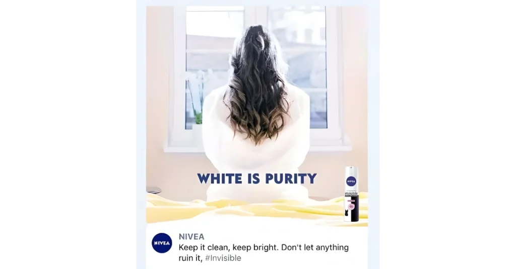 Rear-view woman in white robe and bright room beside Nivea Invisible deodorant can under headline โWhite Is Purityโ