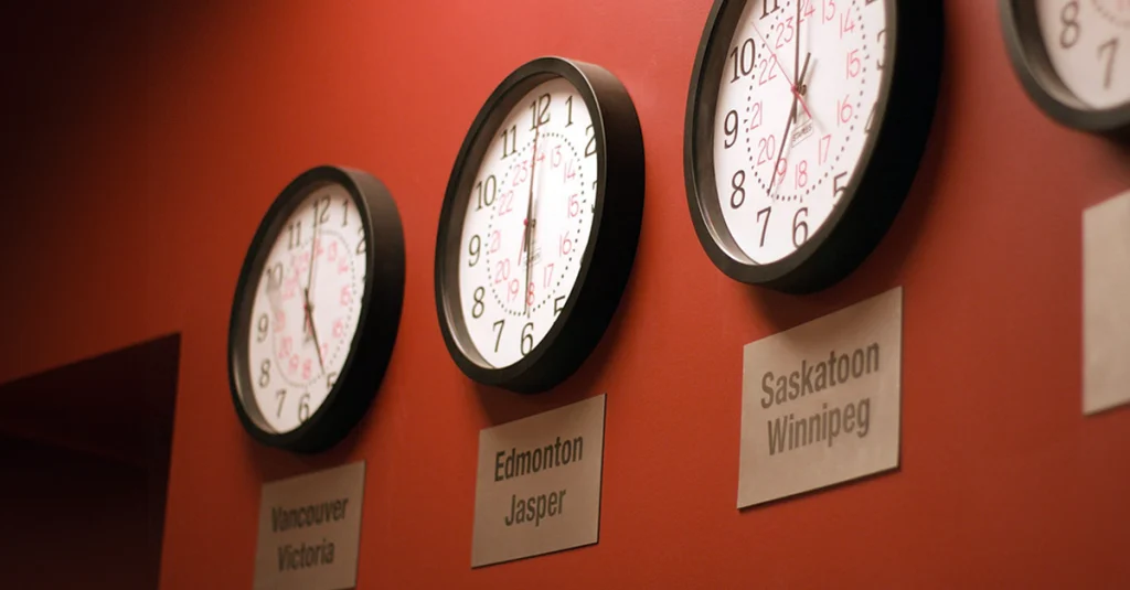 Wall clocks showing different time zones in Vancouver, Edmonton, and Saskatoon